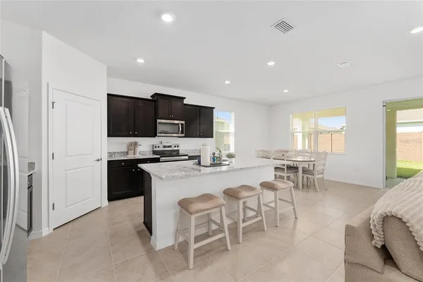 a kitchen with stainless steel appliances a sink a stove a refrigerator a center island and a stove