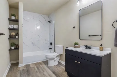 a bathroom with a bathtub sink mirror and toilet