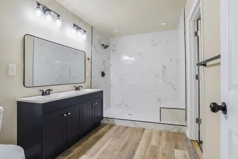 a bathroom with a double vanity sink mirror and shower
