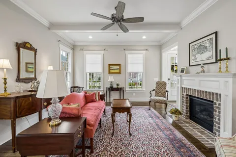 a living room with furniture a fireplace and a chandelier
