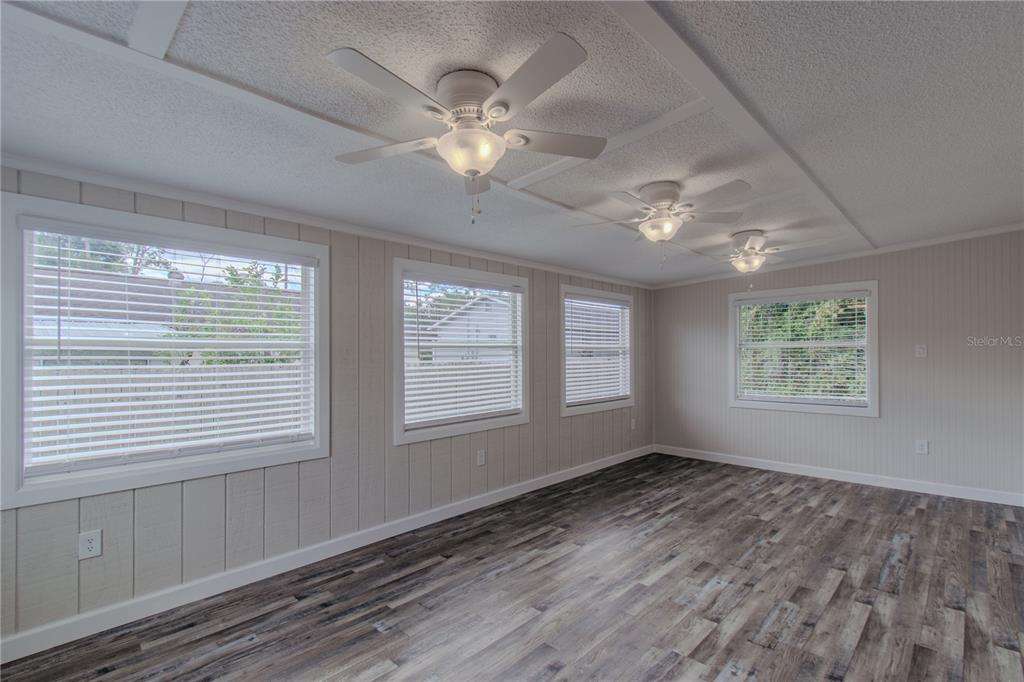 24024 Deer Road Astor, FL 32102 - Photo 16 of 22 a view of an empty room with a window and wooden floor