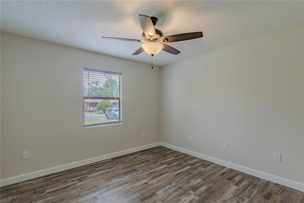 24024 Deer Road Astor, FL 32102 - Photo 17 of 31 an empty room with wooden floor fan and windows