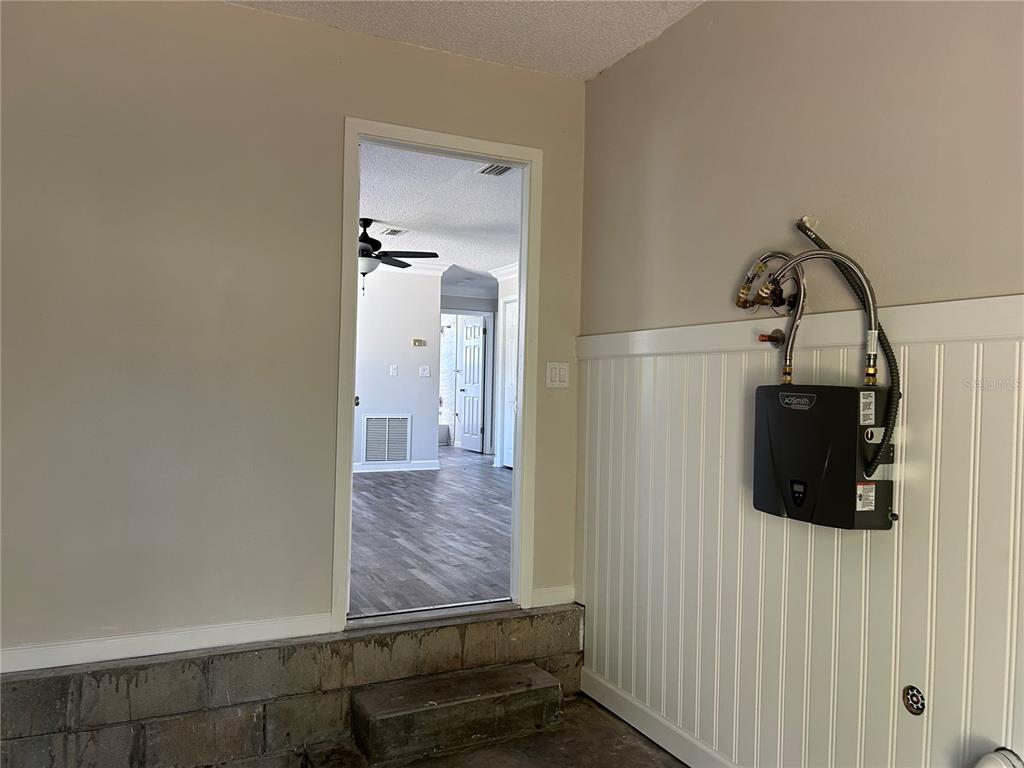 24024 Deer Road Astor, FL 32102 - Photo 28 of 31 a view of a hallway with wooden floor and a bathroom