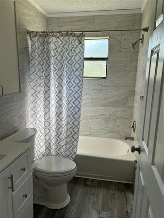 an empty room with wooden floor cabinet and window