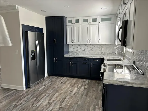 an empty room with wooden floor a ceiling fan and windows