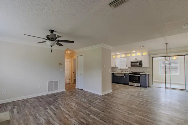 a open kitchen with stainless steel appliances granite countertop a refrigerator and a stove top oven