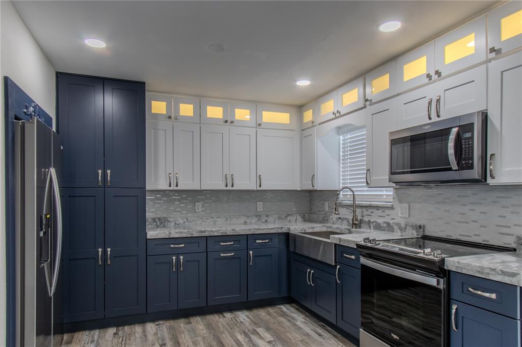24024 Deer Road Astor, FL 32102 - Photo 7 of 22 a kitchen with stainless steel appliances granite countertop a stove a sink and a microwave