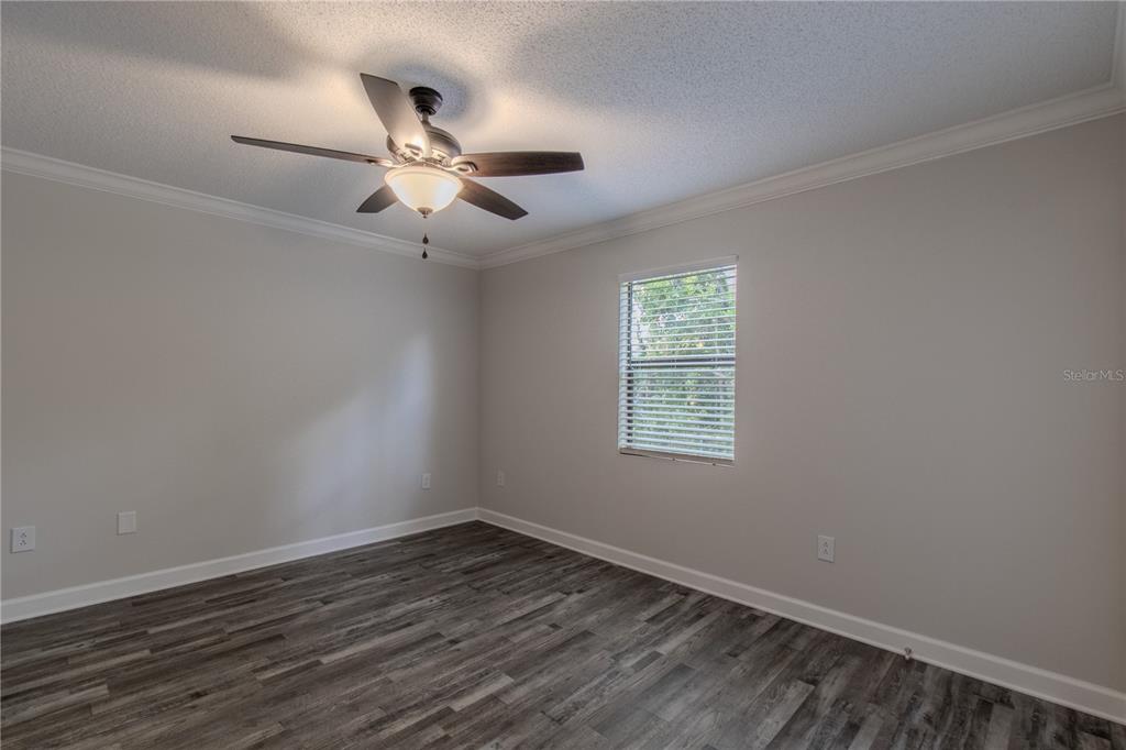 24024 Deer Road Astor, FL 32102 - Photo 8 of 22 wooden floor in an empty room with a window