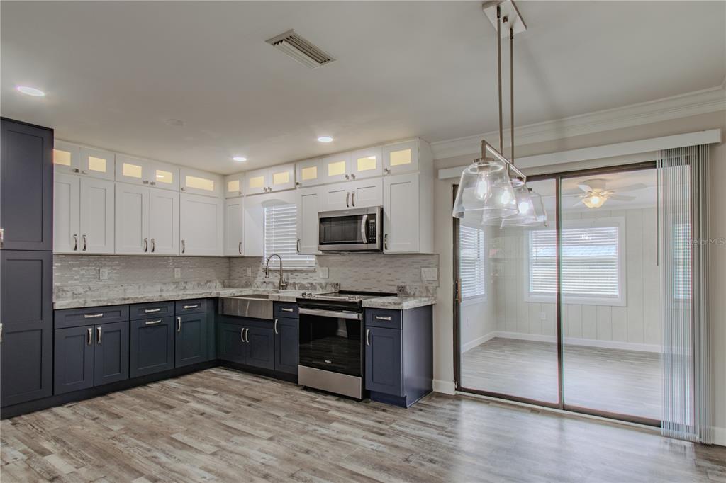24024 Deer Road Astor, FL 32102 - Photo 10 of 31 a kitchen with stainless steel appliances granite countertop a sink and a refrigerator