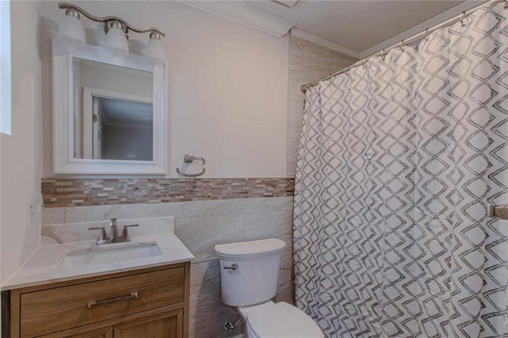 24024 Deer Road Astor, FL 32102 - Photo 10 of 22 a bathroom with a granite countertop toilet sink and mirror