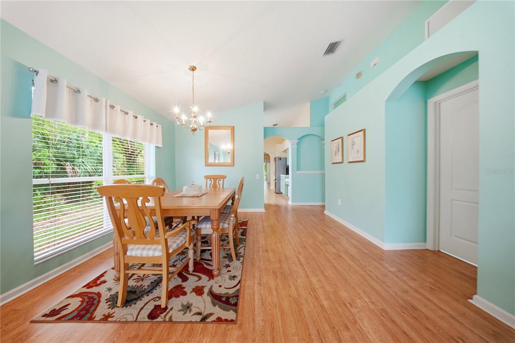 5856 Count Turf Lane Wesley Chapel, FL 33544 - Photo 16 of 57 a dining room with furniture window and wooden floor