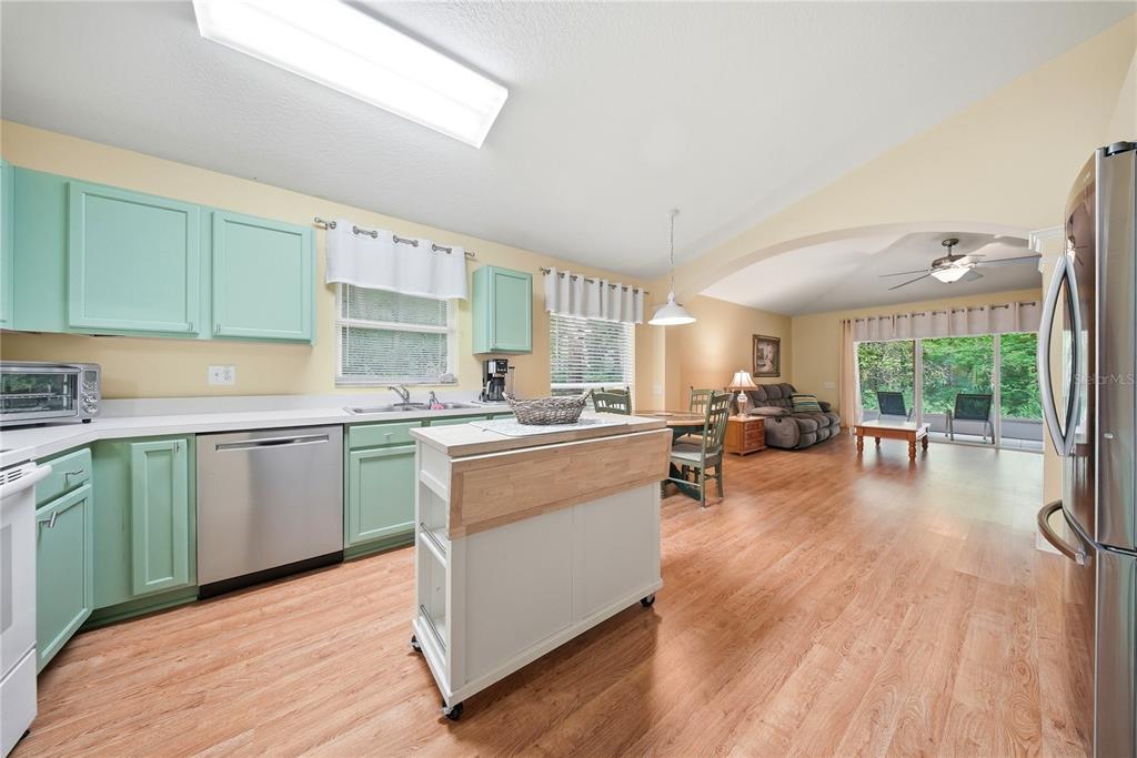 5856 Count Turf Lane Wesley Chapel, FL 33544 - Photo 2 of 57 a kitchen with sink cabinets and wooden floor