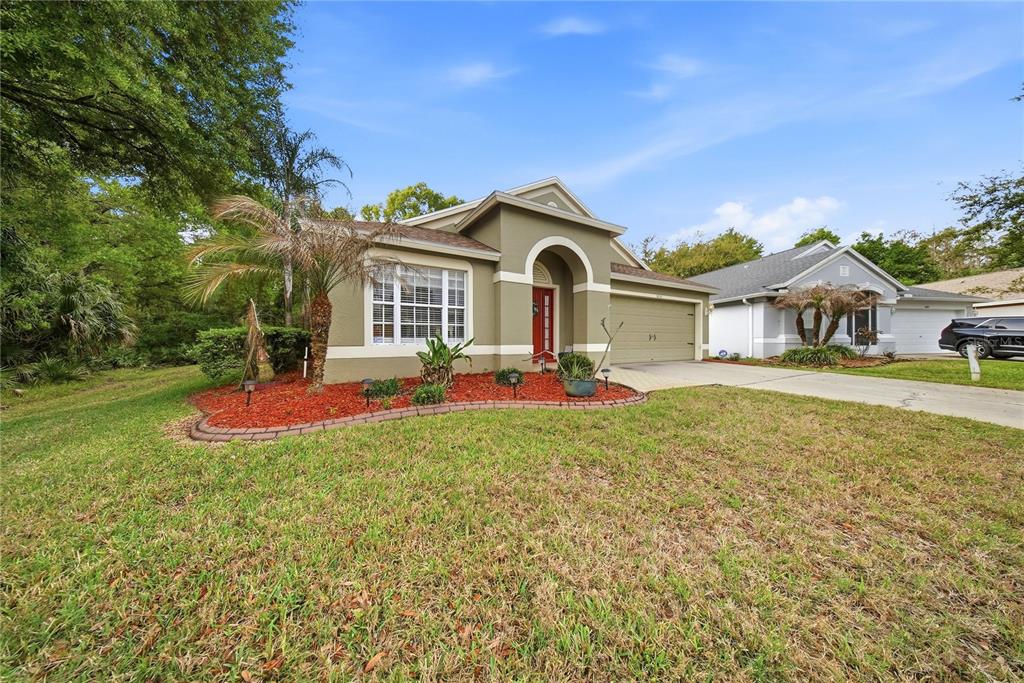 5856 Count Turf Lane Wesley Chapel, FL 33544 - Photo 23 of 57 a front view of a house with a yard and trees