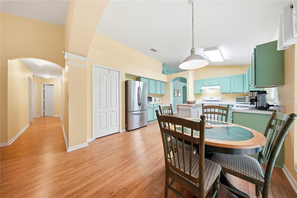 5856 Count Turf Lane Wesley Chapel, FL 33544 - Photo 31 of 57 a dining room with furniture a kitchen a chandelier and wooden floor
