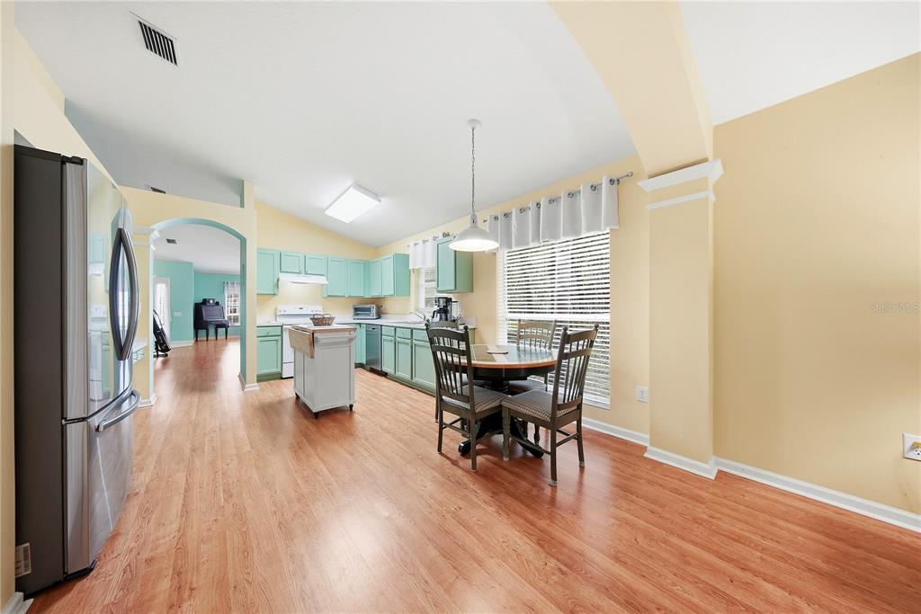 5856 Count Turf Lane Wesley Chapel, FL 33544 - Photo 32 of 57 a view of a dining room with furniture and wooden floor