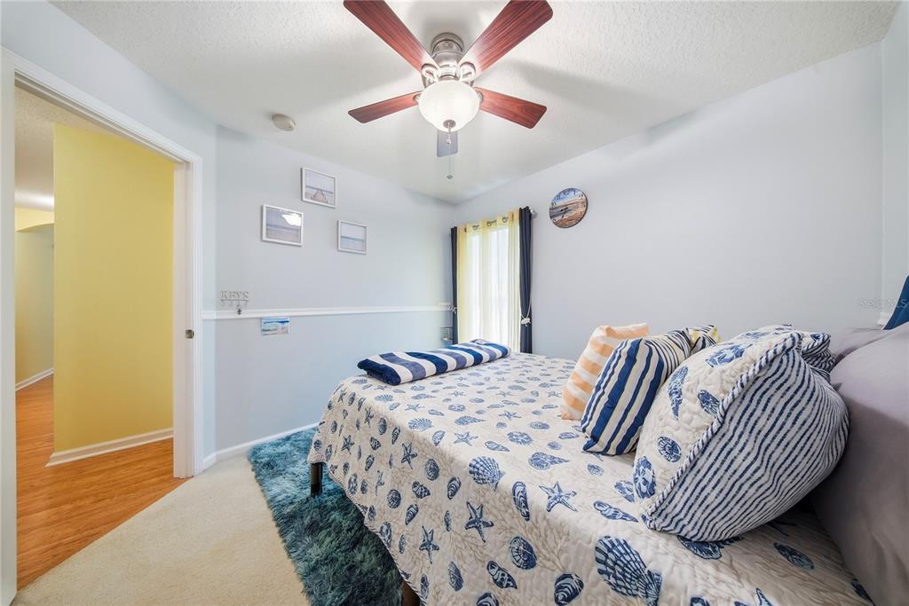5856 Count Turf Lane Wesley Chapel, FL 33544 - Photo 33 of 57 a bedroom with a bed and a chandelier