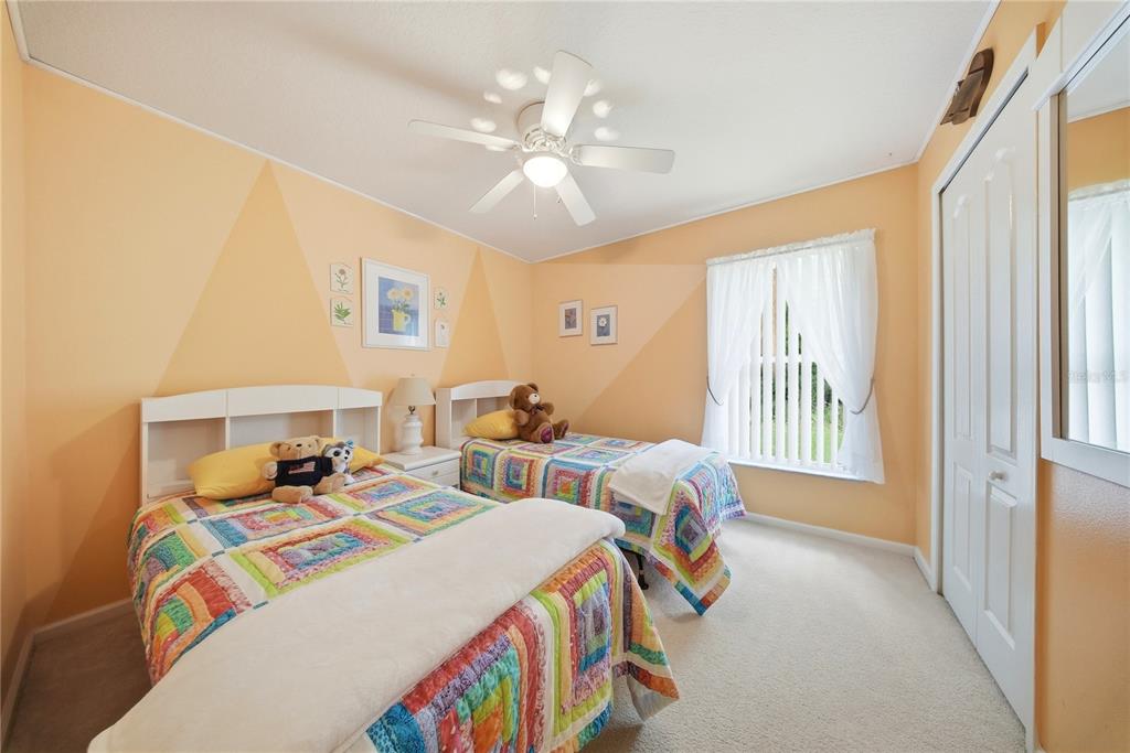 5856 Count Turf Lane Wesley Chapel, FL 33544 - Photo 35 of 57 a bedroom with two beds and a chandelier