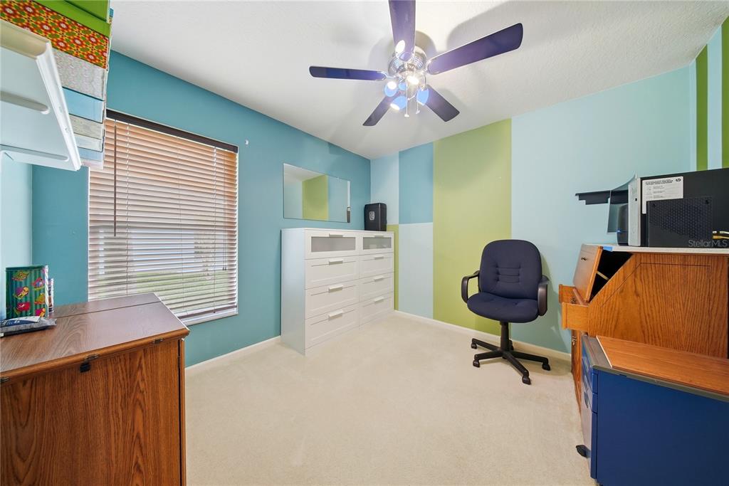 5856 Count Turf Lane Wesley Chapel, FL 33544 - Photo 37 of 57 a bedroom with a bed and a chandelier