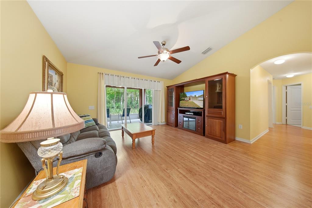 5856 Count Turf Lane Wesley Chapel, FL 33544 - Photo 4 of 57 a living room with furniture floor to ceiling window and wooden floor