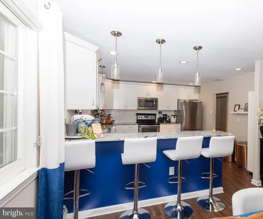 a living room with lots of furniture and kitchen view