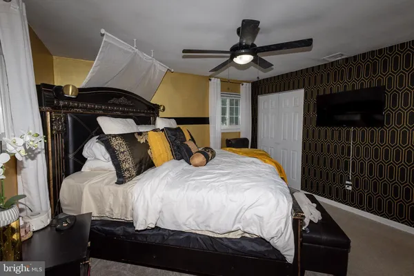 a bedroom with a bed a flat screen tv and a chandelier