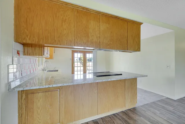 a kitchen with stainless steel appliances granite countertop a sink and a wooden cabinets