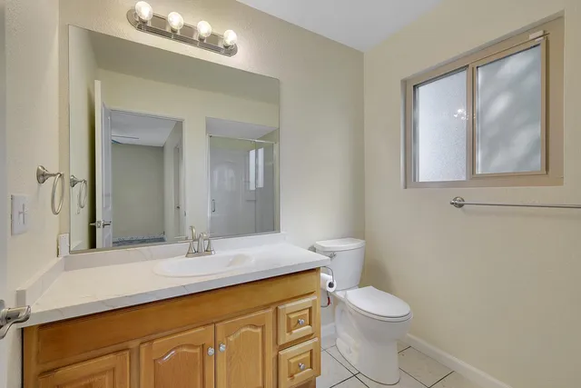 a bathroom with a toilet a sink a vanity and mirror