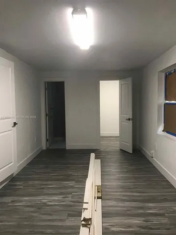 an empty room with wooden floor and closet