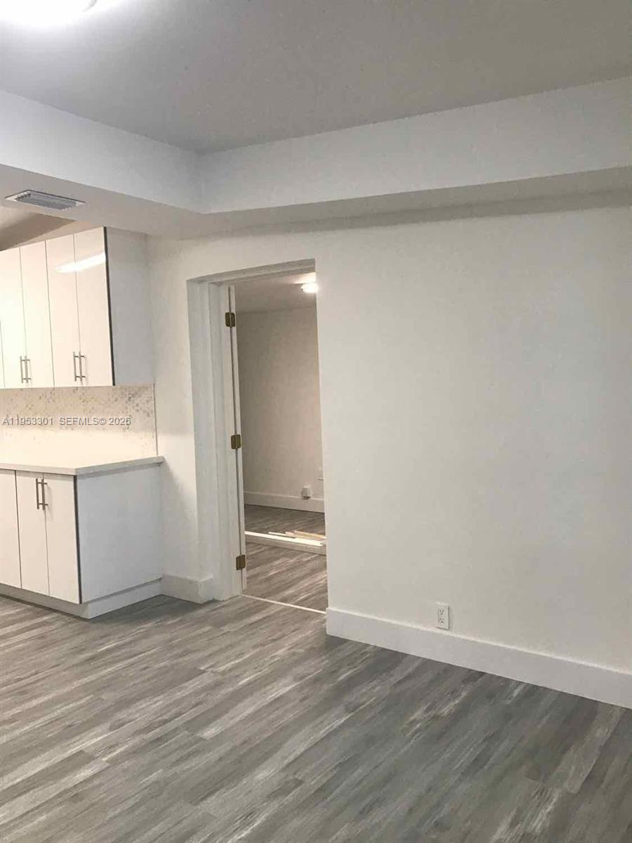1920 Rutland Street Opa-Locka, FL 33054 - Photo 17 of 33 a view of an empty room with wooden floor and a window