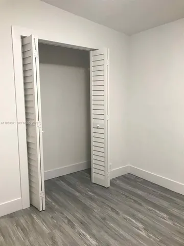 an empty room with wooden floor and closet