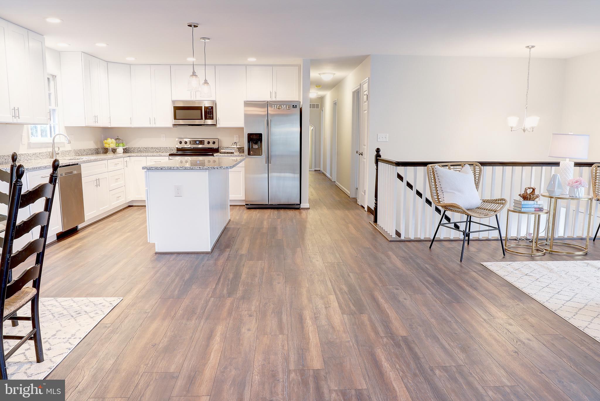695 Hillmeade Road Edgewater, MD 21037 - Photo 8 of 28 a kitchen with stainless steel appliances kitchen island wooden floors and white cabinets