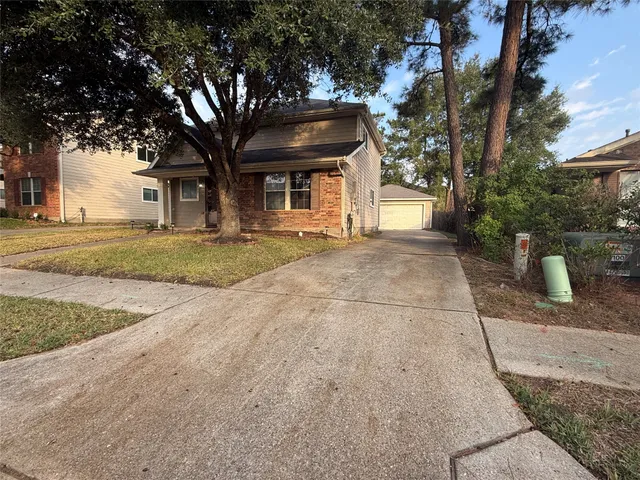 a front view of a house with a yard and trees