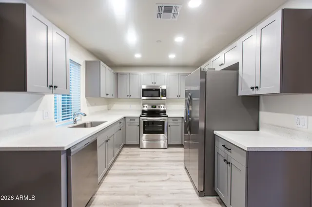 a kitchen with stainless steel appliances a refrigerator sink and stove