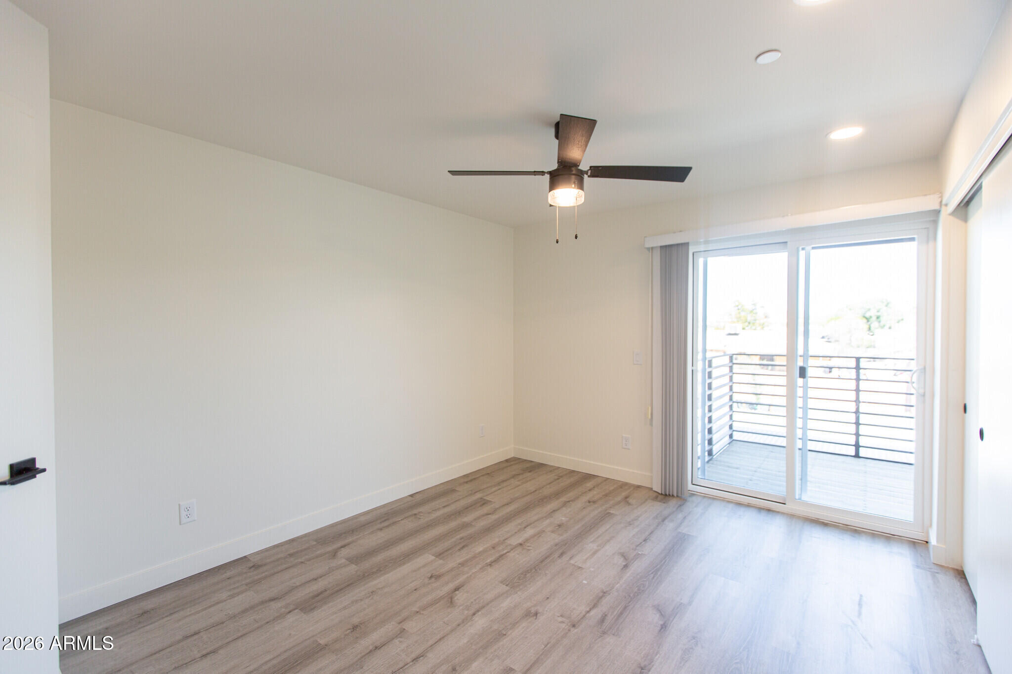 3644 East McDowell Road, Unit 101 Phoenix, AZ 85008 - Photo 20 of 21 an empty room with wooden floor fan and windows