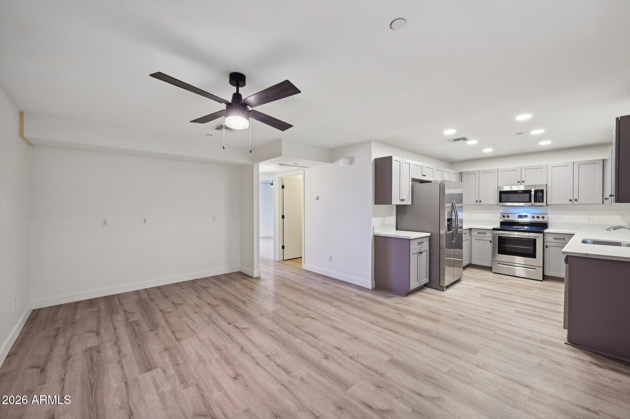 3644 East McDowell Road, Unit 101 Phoenix, AZ 85008 - Photo 3 of 21 a kitchen with stainless steel appliances a stove top oven a sink dishwasher and a refrigerator with wooden floor