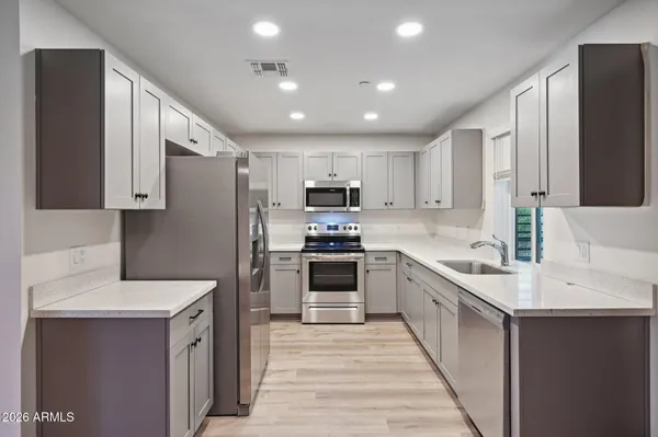 a kitchen with granite countertop a sink stove and refrigerator