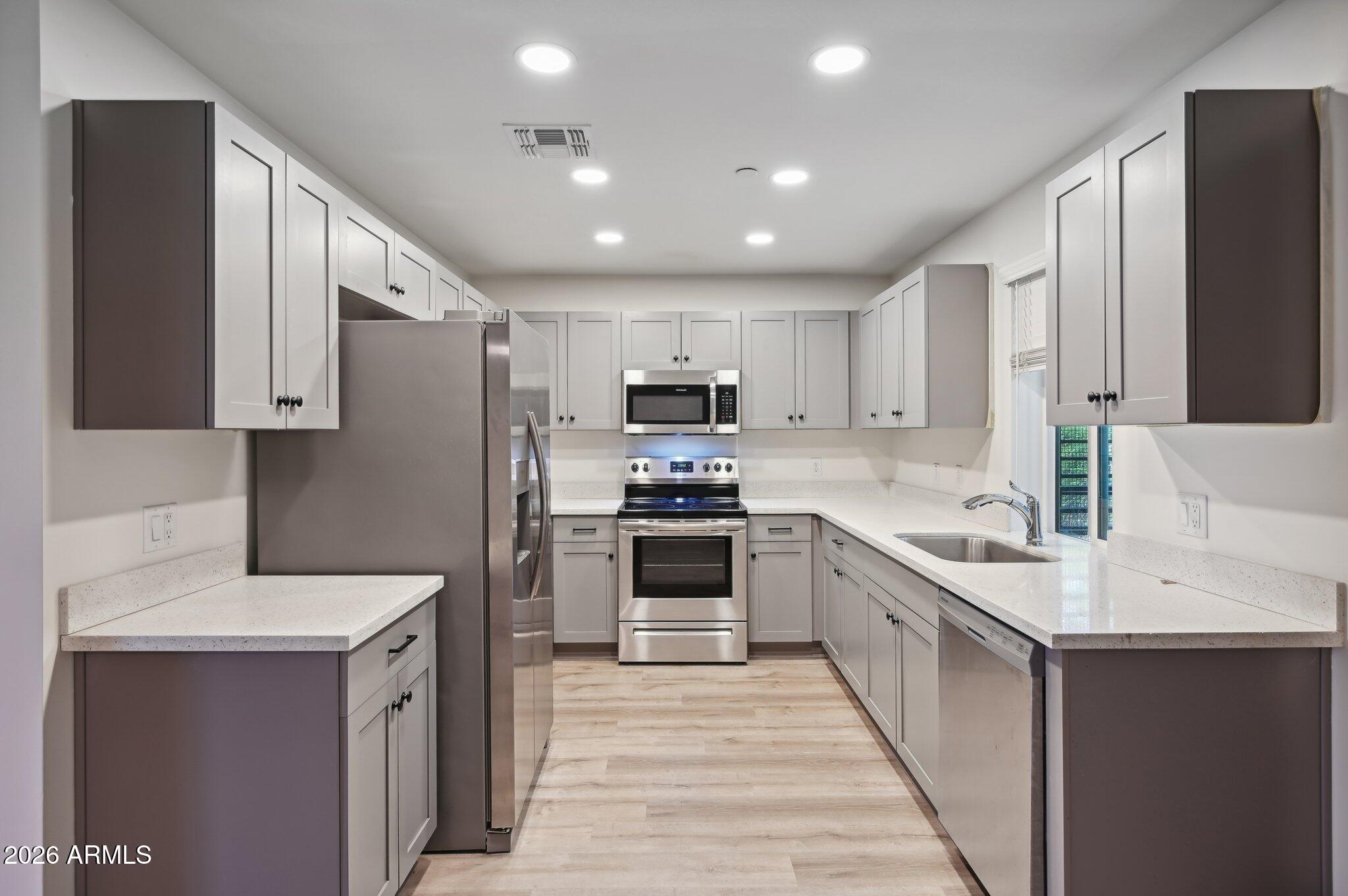 3644 East McDowell Road, Unit 101 Phoenix, AZ 85008 - Photo 5 of 21 a kitchen with granite countertop a sink stove and refrigerator