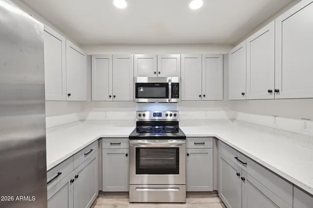 a kitchen with white cabinets and appliances