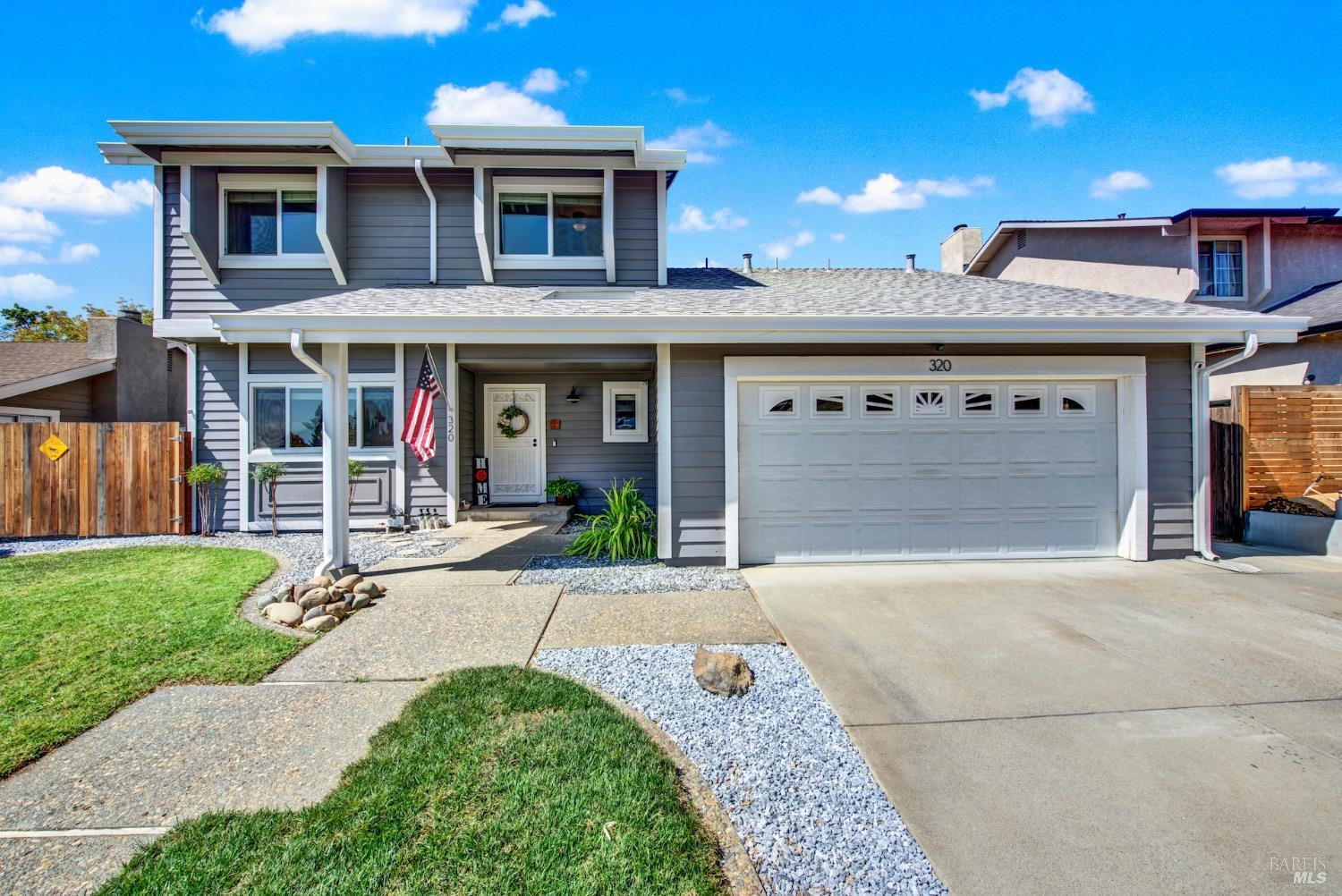 a front view of a building with a garden and plants