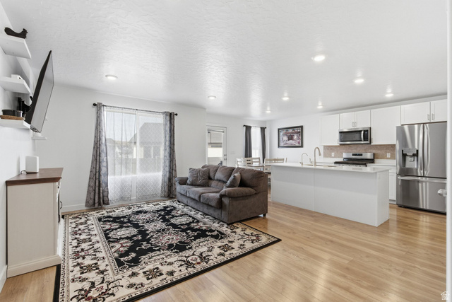3808 Galatia Road Magna, UT 84044 - Photo 6 of 59 Open-concept living area featuring light wood-finish flooring throughout