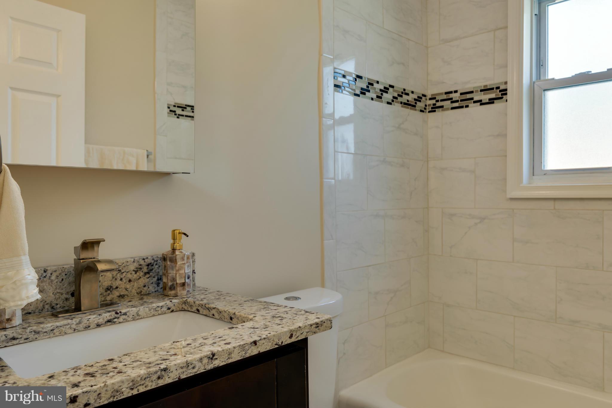 3310 Harrell Street Silver Spring, MD 20906 - Photo 13 of 26 a bathroom with a granite countertop sink a toilet and shower