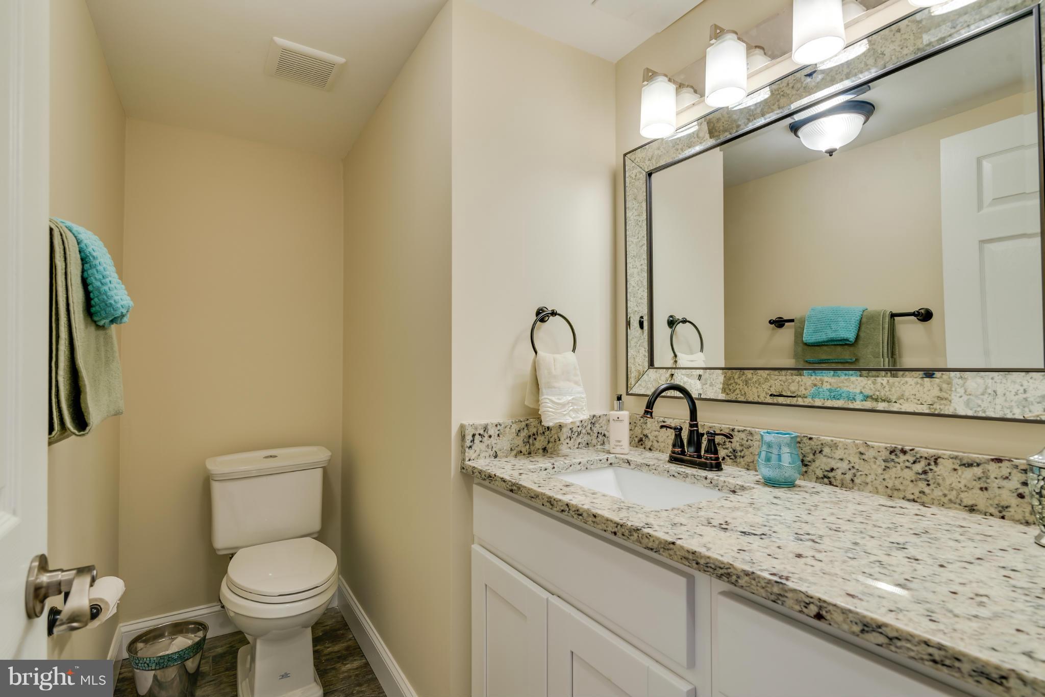 3310 Harrell Street Silver Spring, MD 20906 - Photo 21 of 26 a bathroom with a granite countertop toilet sink and mirror