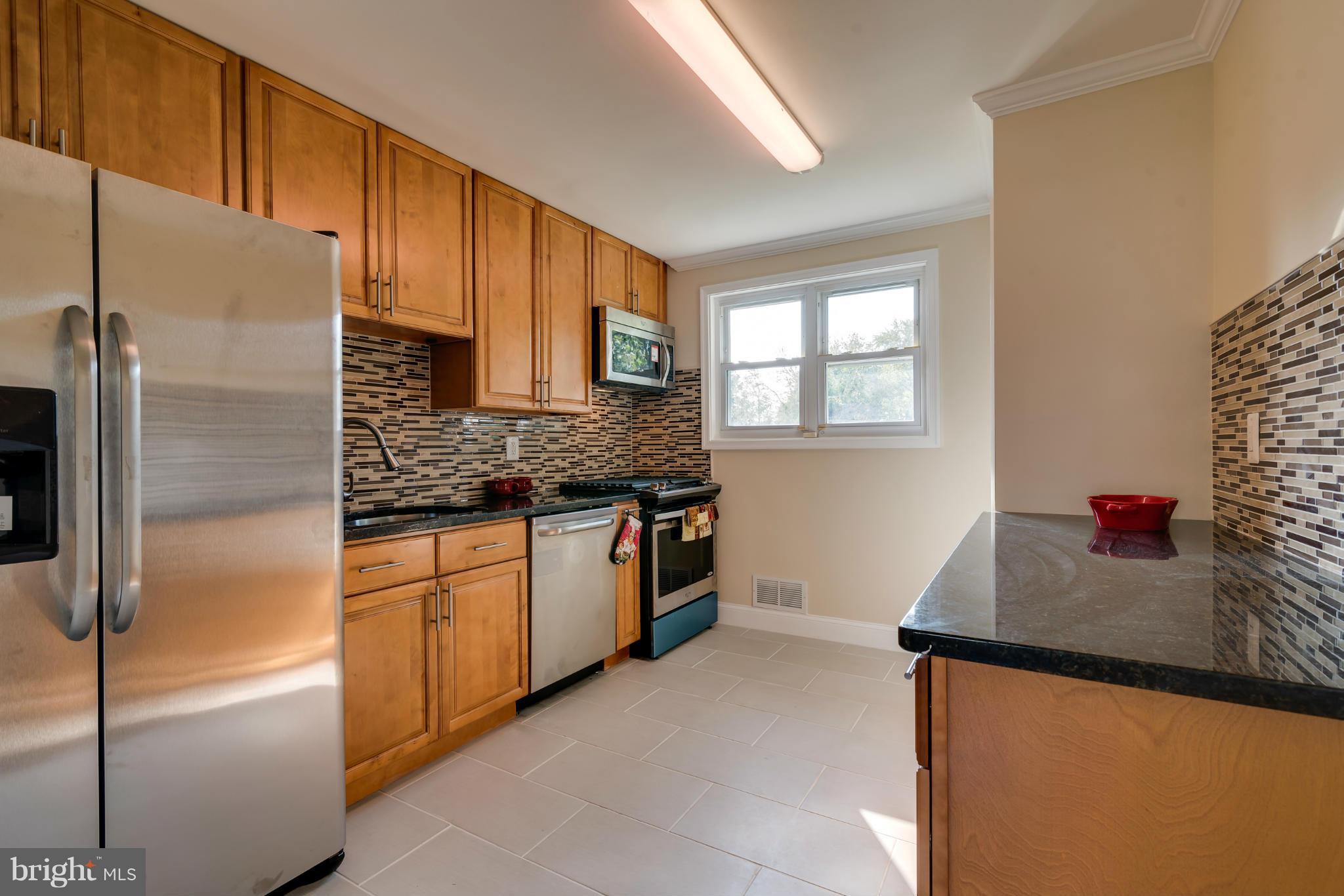 3310 Harrell Street Silver Spring, MD 20906 - Photo 4 of 26 a kitchen with stainless steel appliances granite countertop a refrigerator sink and cabinets