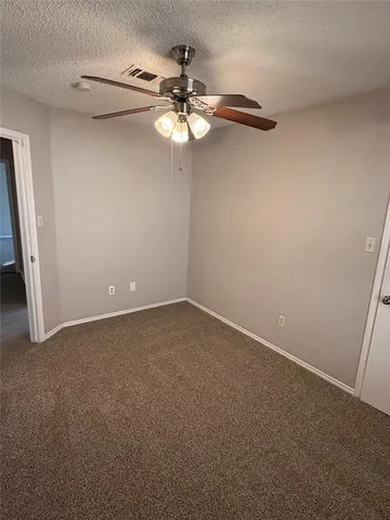 a view of a small space with a chandelier fan and wooden floor
