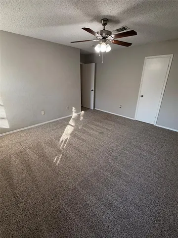 a view of a livingroom with a ceiling fan and window