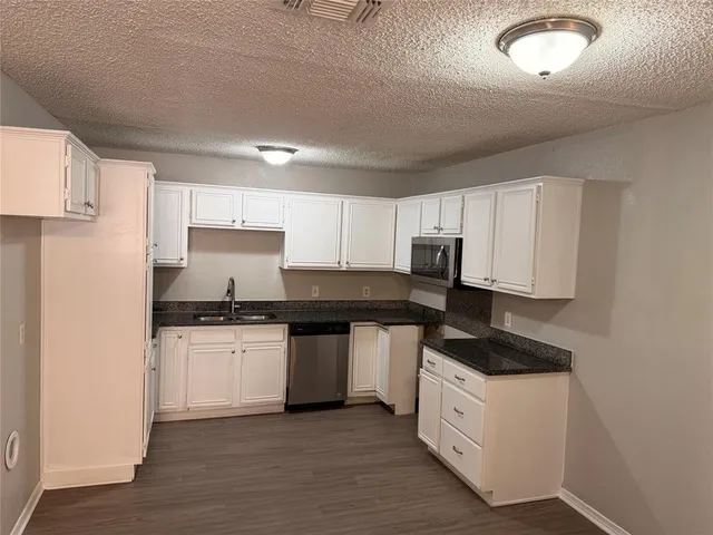 a kitchen with stainless steel appliances a sink stove and cabinets