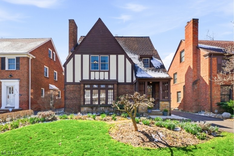 Front exterior of Tudor style home with mature landscaping.