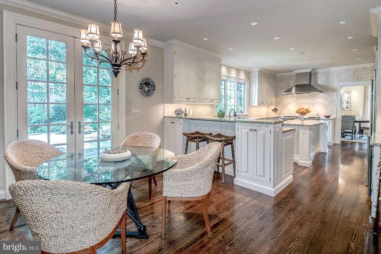 5511 Cornish Road Bethesda, MD 20814 - Photo 12 of 30 a dining room with wooden floor a chandelier a glass table and chairs