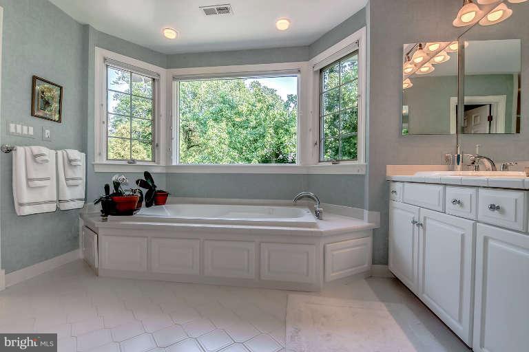 5511 Cornish Road Bethesda, MD 20814 - Photo 19 of 30 a bathroom with a bathtub a sink a vanity and windows