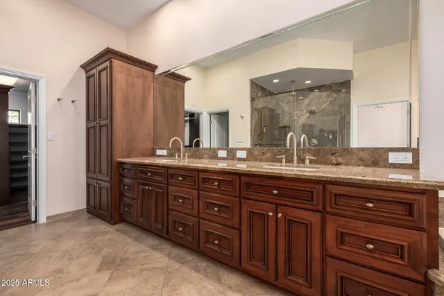 a bathroom with a granite countertop tub sink and mirror